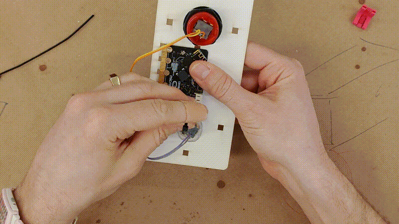 a short video clip showing the micro:bit being secured to the top panel with a zip tie