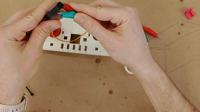 a short video clip showing a red button getting secured to the top panel using a locking collar