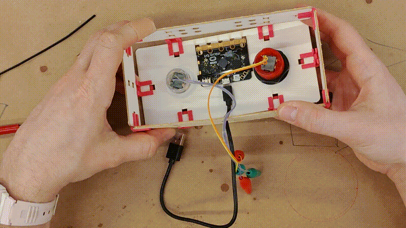 a short video clip showing the ring that forms the side walls of the controller being secured to the top panel using previously installed Clip-Os